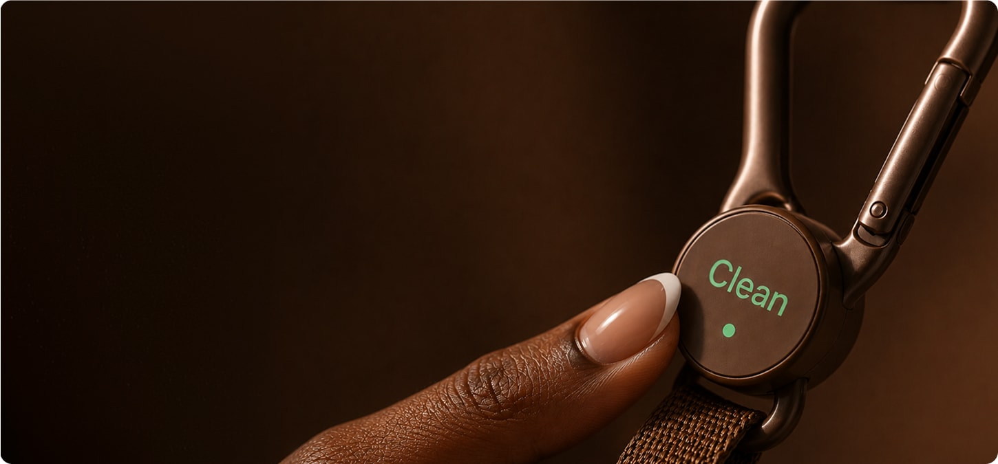 Finger resting on the “clean” status screen on the Loop clip.
